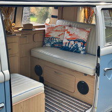 Load image into Gallery viewer, Two coastal cushion covers featuring a blue and orange graphic design sit in a classic campervan on the sofa