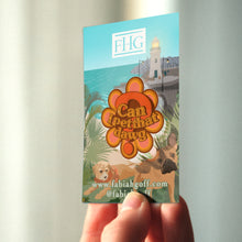 Load image into Gallery viewer, Hand holding a colorful card with a lighthouse and floral design, featuring the text &#39;Can I pet that dog?&#39; and &#39;FHG&#39; (Fabia Hebe Goff Logo)

